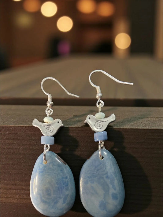 Delicate silver heather blue tagua grain earrings with swirl birds and light blue marbled teardrop pendants and beads