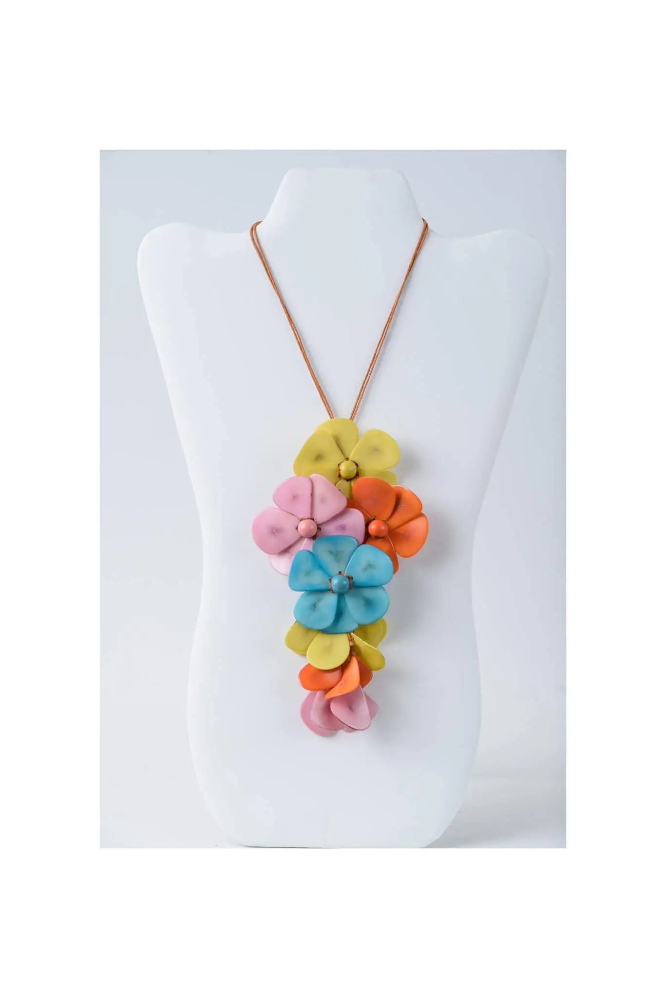 A vibrant multi-colored holly pendant flower tagua necklace with layered pink yellow orange and blue fabric blossoms