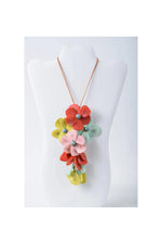 A holly pendant flower tagua necklace with vibrant red pink yellow and mint green layered fabric blossoms and metallic beads