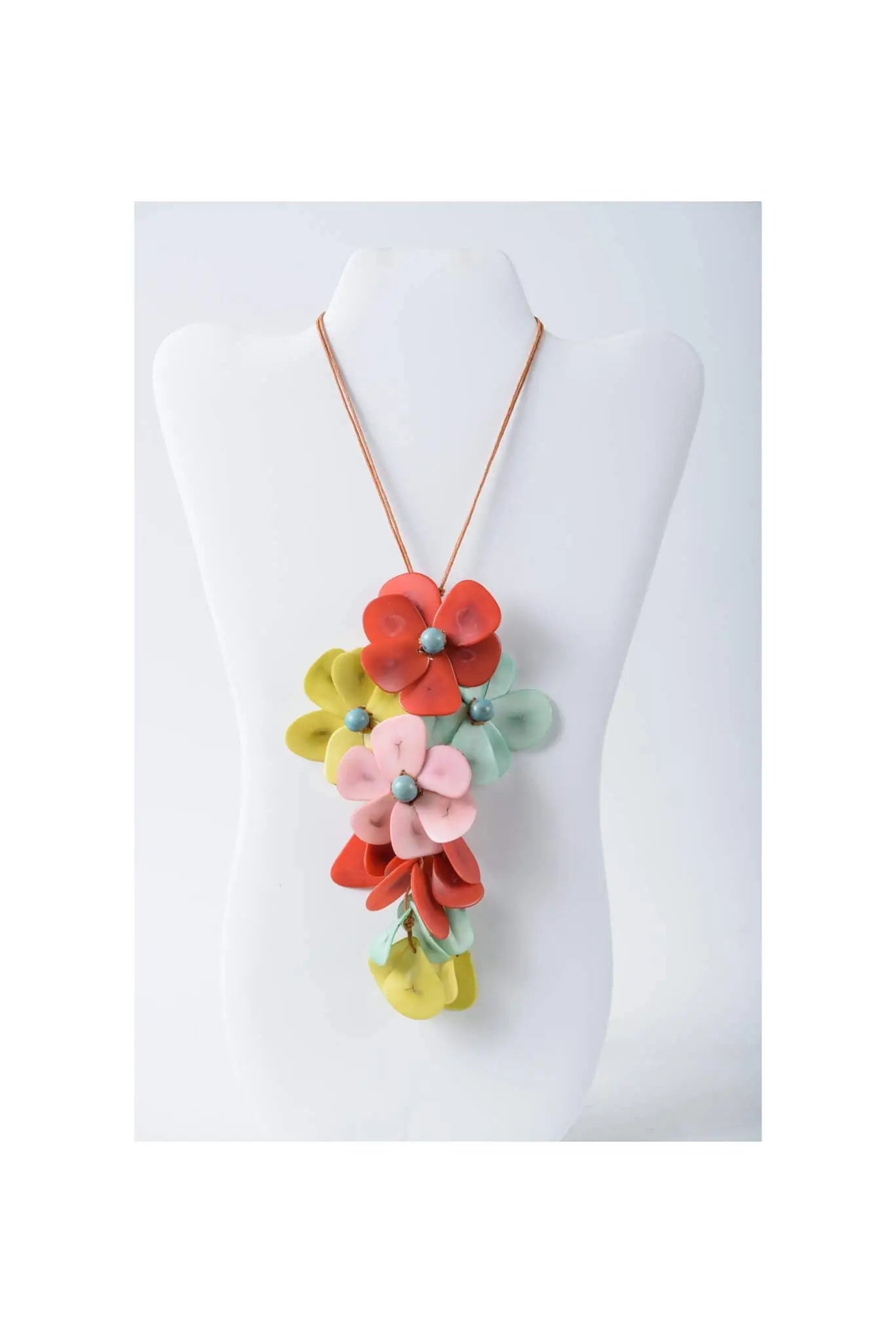 A holly pendant flower tagua necklace with vibrant red pink yellow and mint green layered fabric blossoms and metallic beads