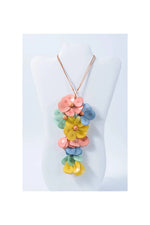 A vibrant holly pendant flower tagua necklace with pastel pink yellow blue and green petals in a cascading design