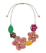 Ibbie necklace featuring colorful handcrafted painted wooden flower and leaf pendants with natural tagua nut centers
