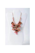 Layered ivy cascading tagua necklace with pink and brown leather-like button pendants on a peach beaded chain