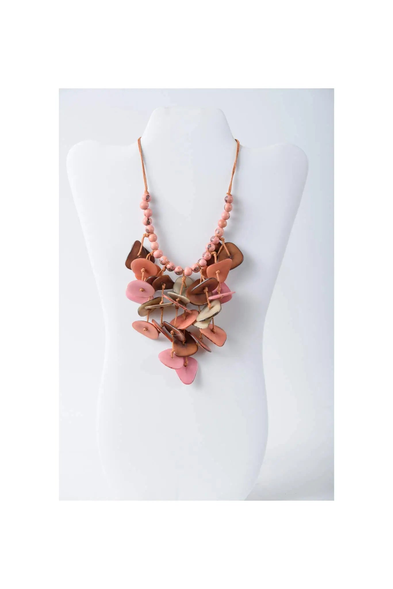 Layered ivy cascading tagua necklace with pink and brown leather-like button pendants on a peach beaded chain