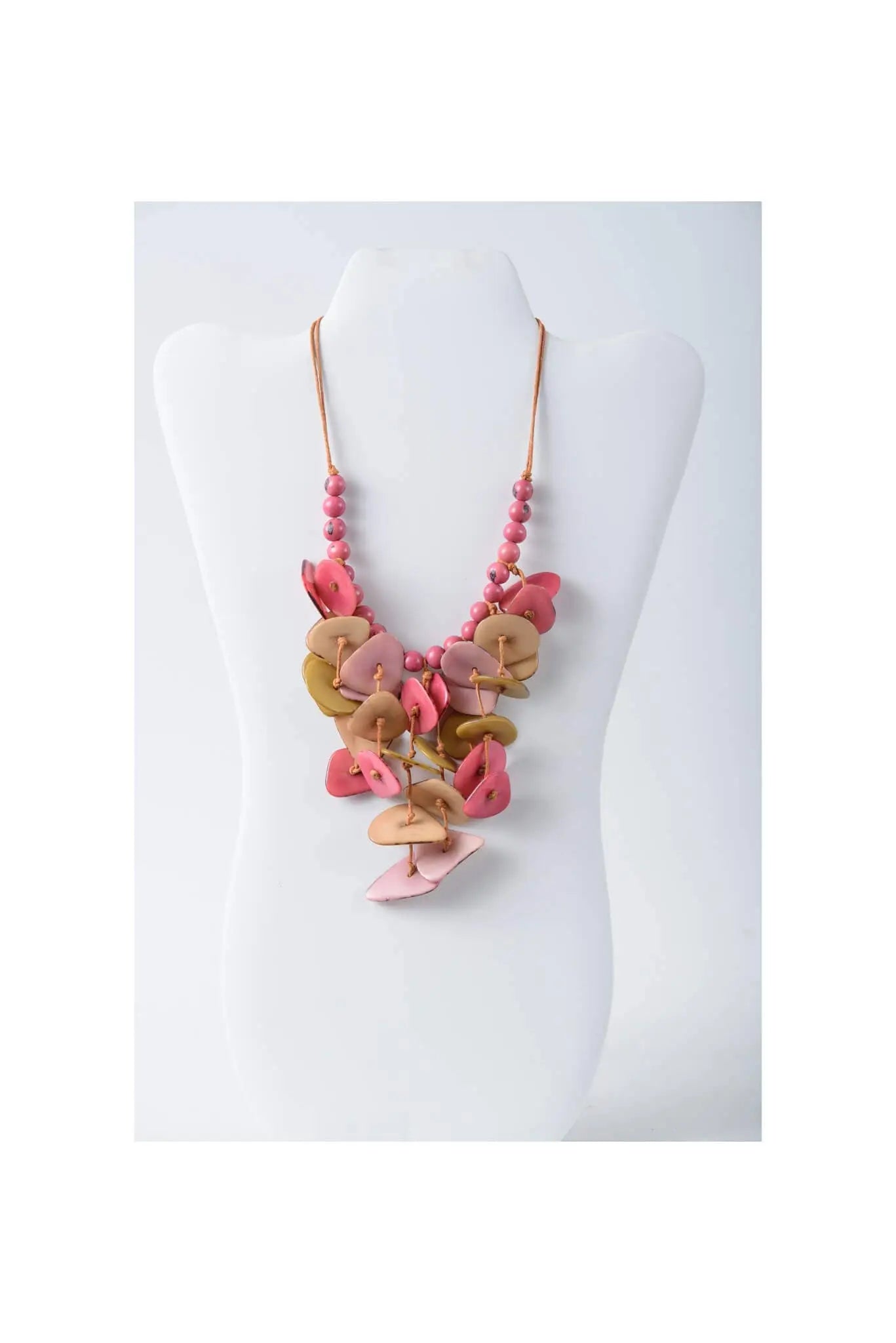 A layered tagua necklace with cascading pink and beige button-like discs on a delicate beaded chain in coastal aqua