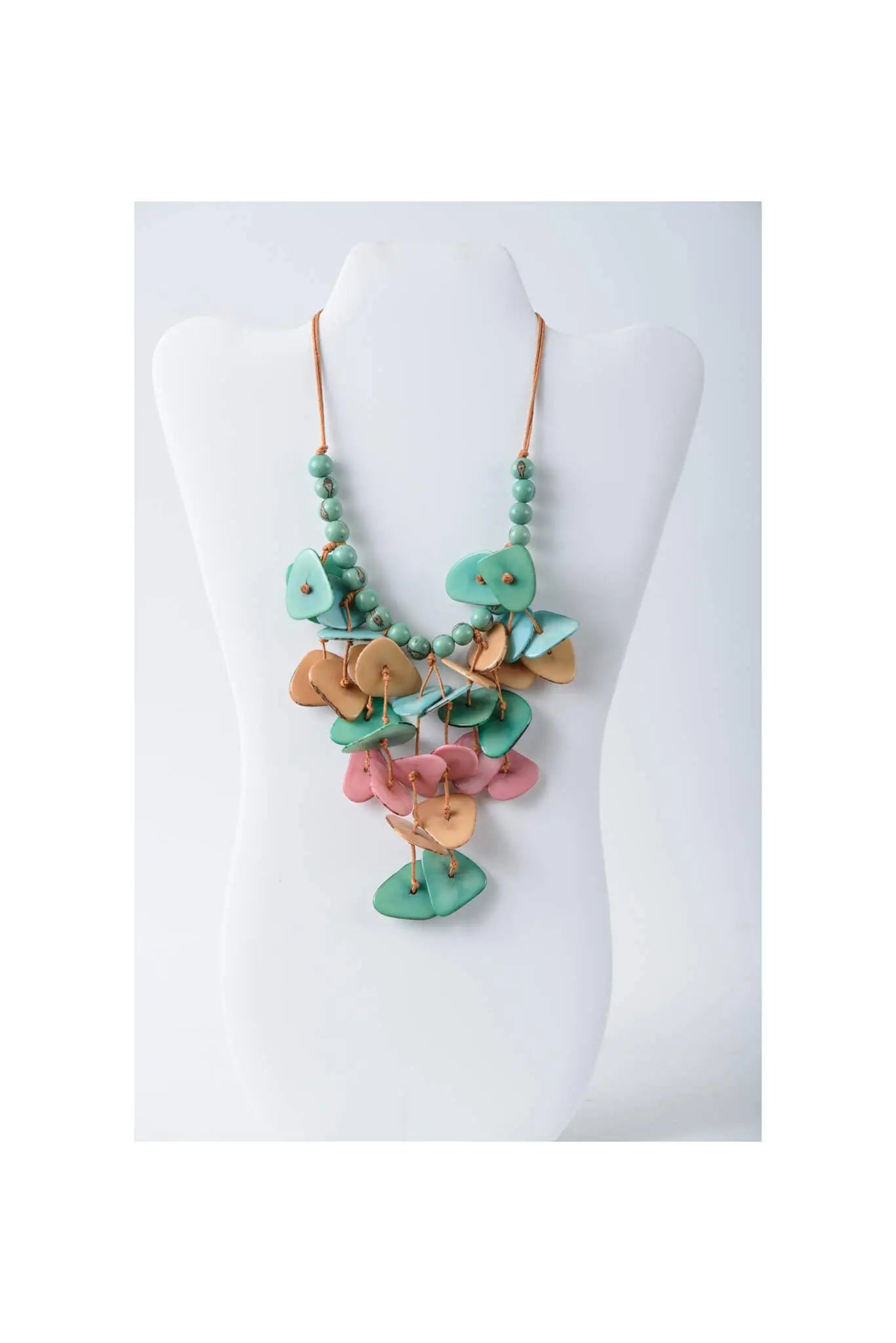 Ivy cascading tagua necklace featuring layered leaf pendants in teal tan and pink on a copper-toned chain