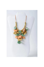 Ivy cascading tagua necklace featuring layered heart and circle leather pieces in sage green peach and mustard yellow