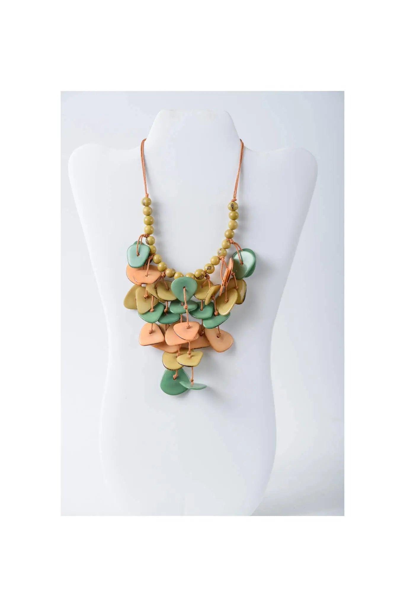 Ivy cascading tagua necklace featuring layered heart and circle leather pieces in sage green peach and mustard yellow