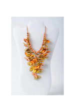 Vibrant orange and yellow layered tagua necklace with flat leaf-shaped wooden pieces and peach-colored beads