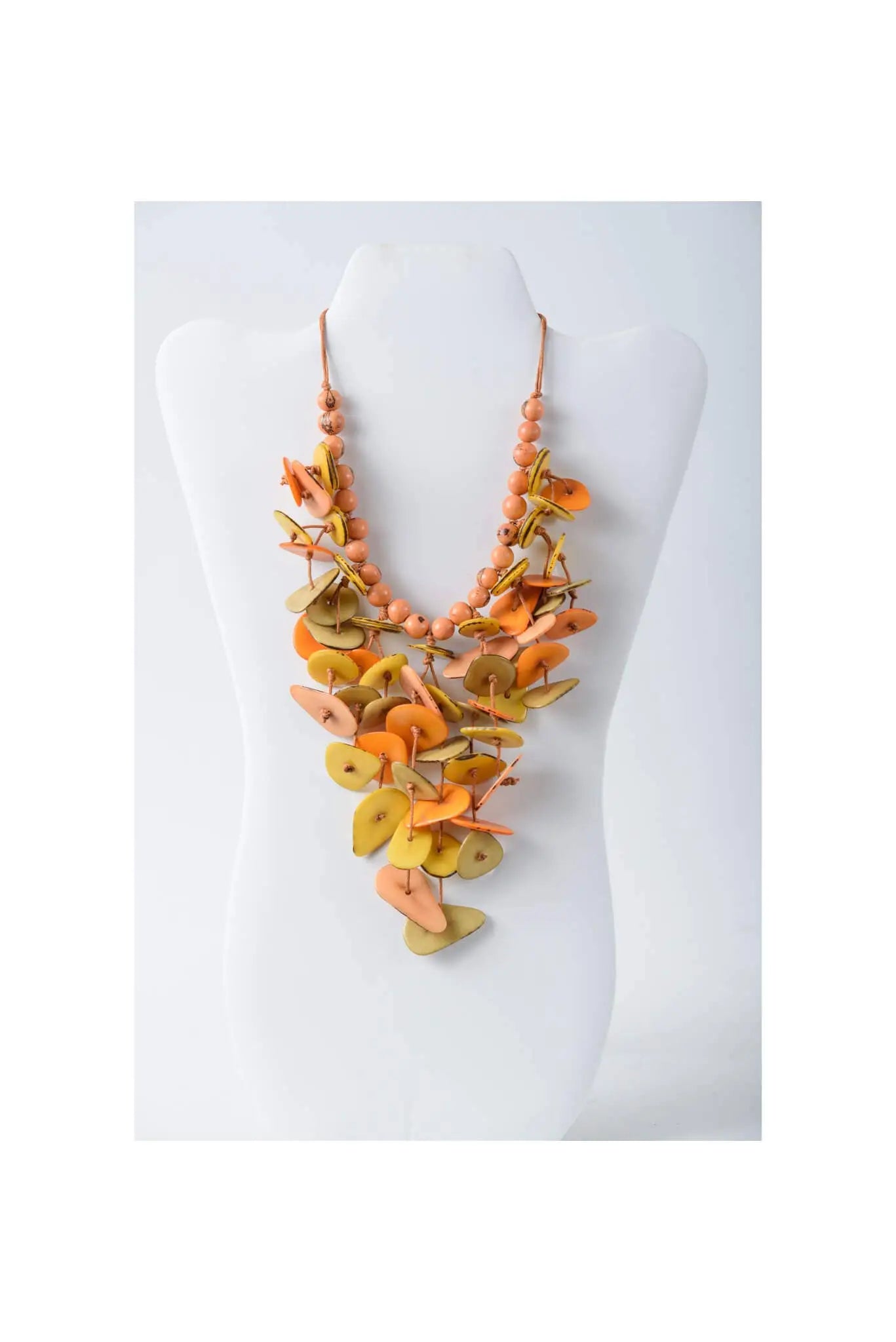 Vibrant orange and yellow layered tagua necklace with flat leaf-shaped wooden pieces and peach-colored beads