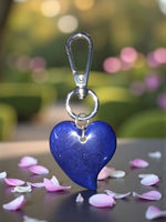 A glossy cobalt blue heart-shaped keychain with a silver carabiner clip perfect as a bag charm