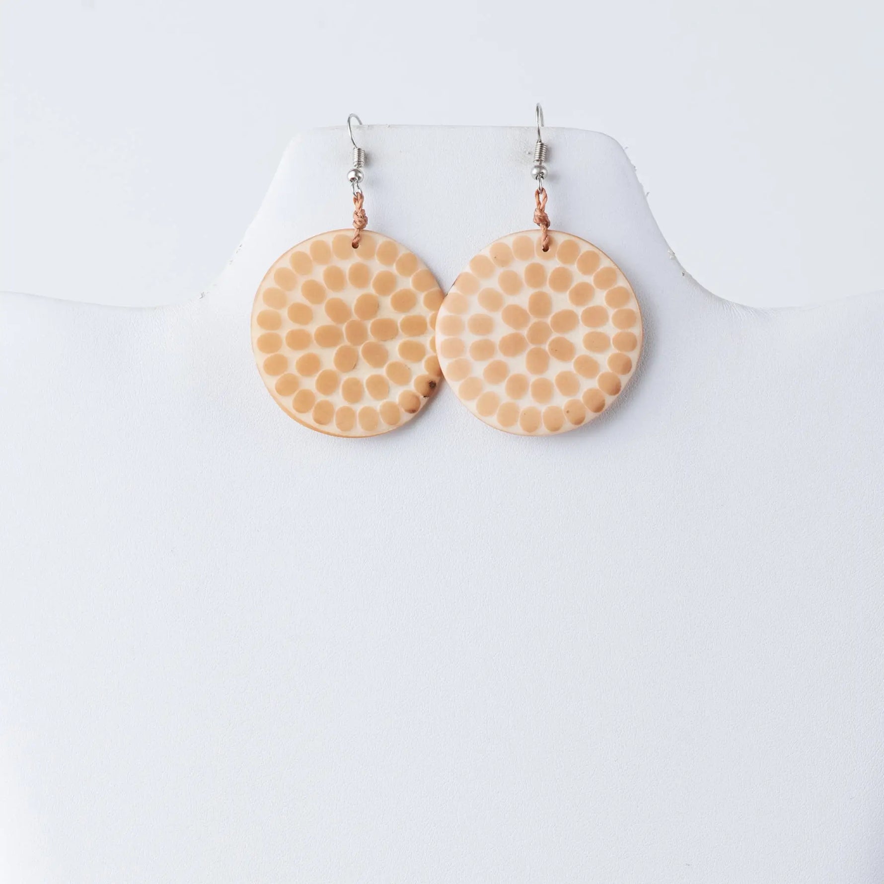 Beige circular engraved tagua earrings with dotted pattern silver hooks and copper jump rings from lana eco-chic