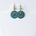 Teal and cream circular engraved tagua earrings with dotted pattern, light green beads and copper wire accents