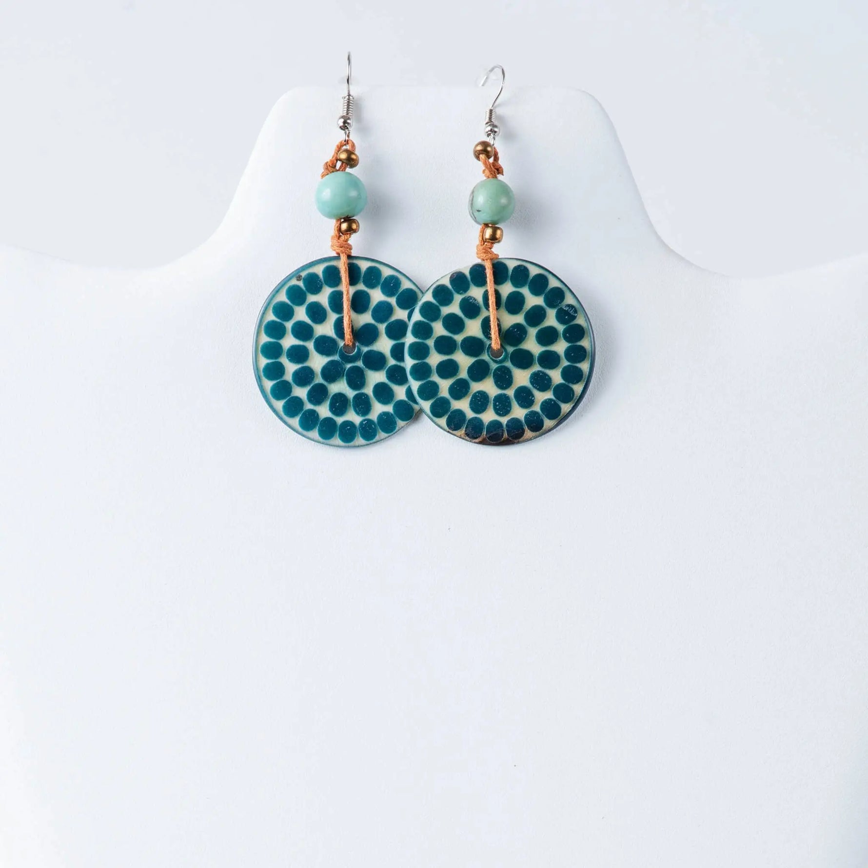 Teal and cream circular engraved tagua earrings with dotted pattern, light green beads and copper wire accents
