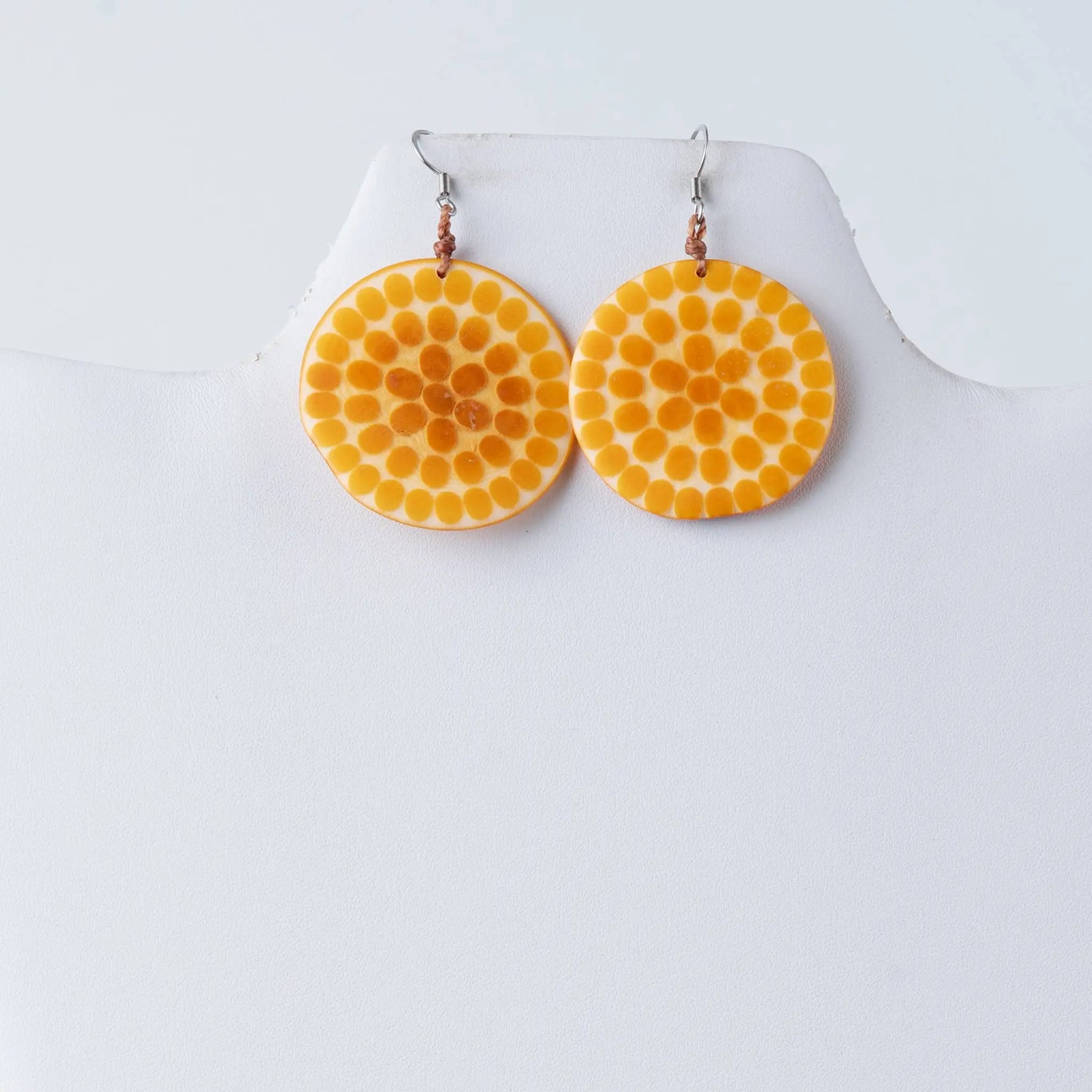 Vibrant orange lana eco-chic engraved tagua earrings with textured dotted pattern and metallic hooks