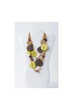 A layered necklace with vibrant lime green and dark brown engraved tagua beads on a natural coconut cord