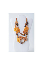 Layered necklace with engraved tagua discs in warm orange and brown tones made from eco-friendly coconut materials