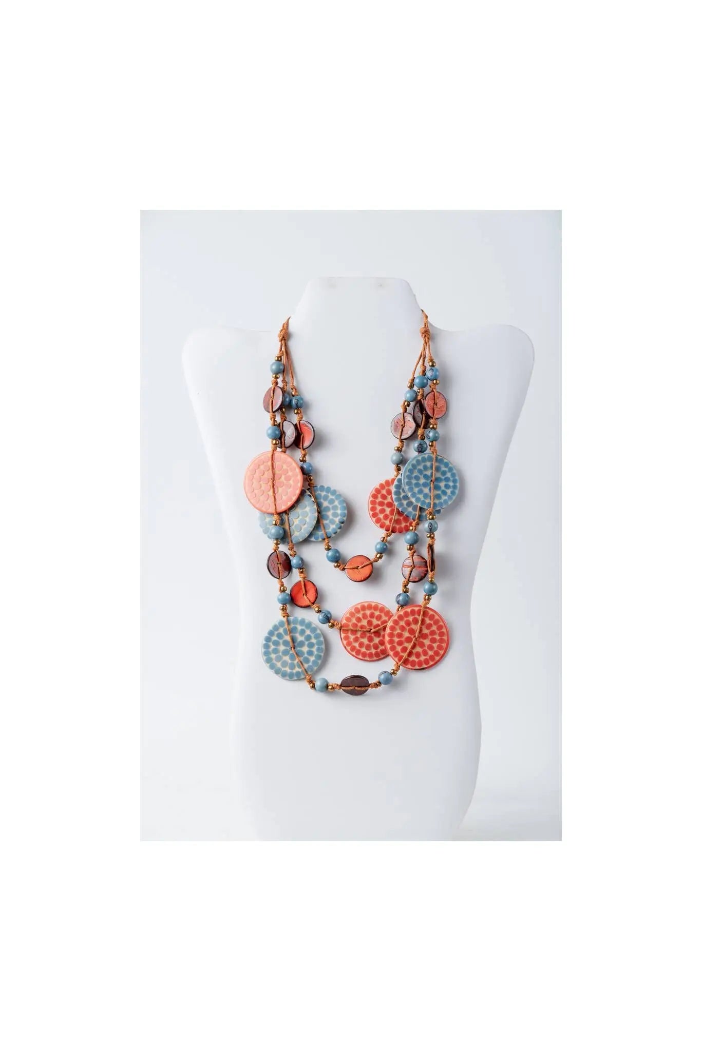 A coral and light blue layered necklace with engraved tagua and metallic beads in the lana eco-chic style