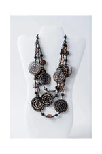 Layered necklace with engraved tagua and coconut beads featuring dark circular beads with intricate dot patterns