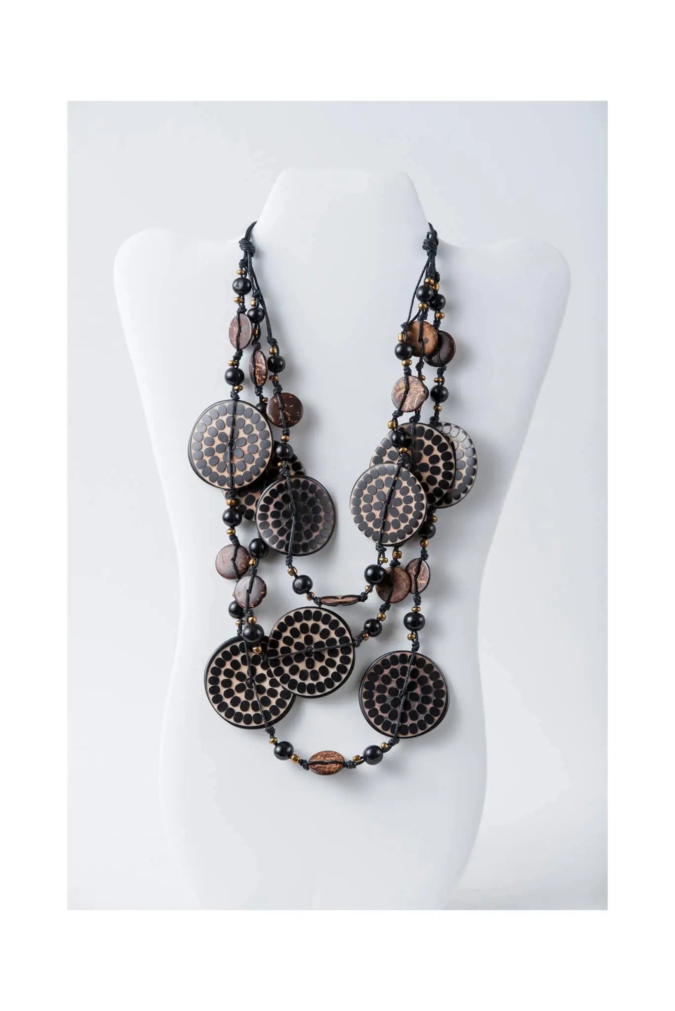 Layered necklace with engraved tagua and coconut beads featuring dark circular beads with intricate dot patterns