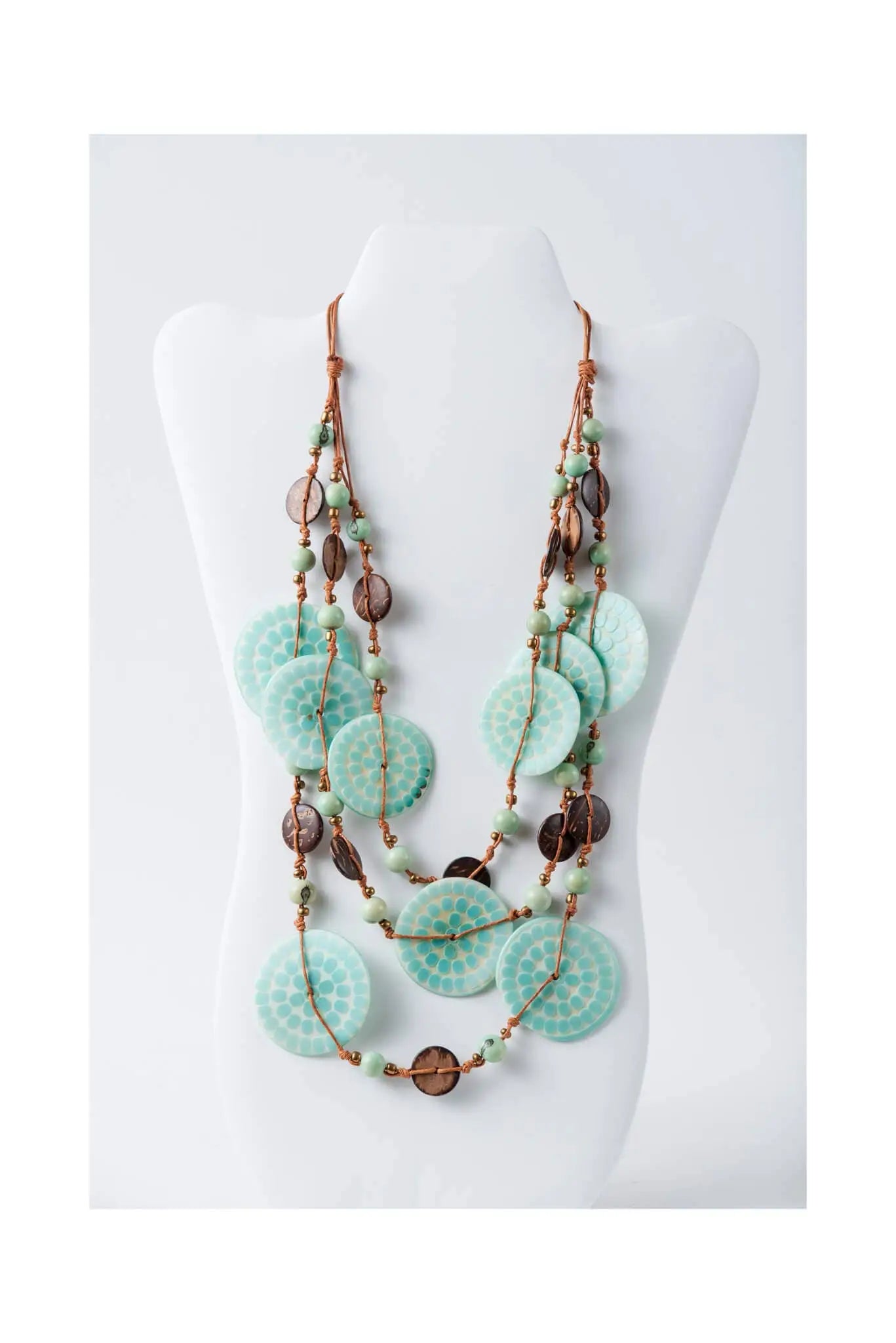 A layered turquoise and copper necklace with engraved tagua beads and textured circular discs from lana eco-chic