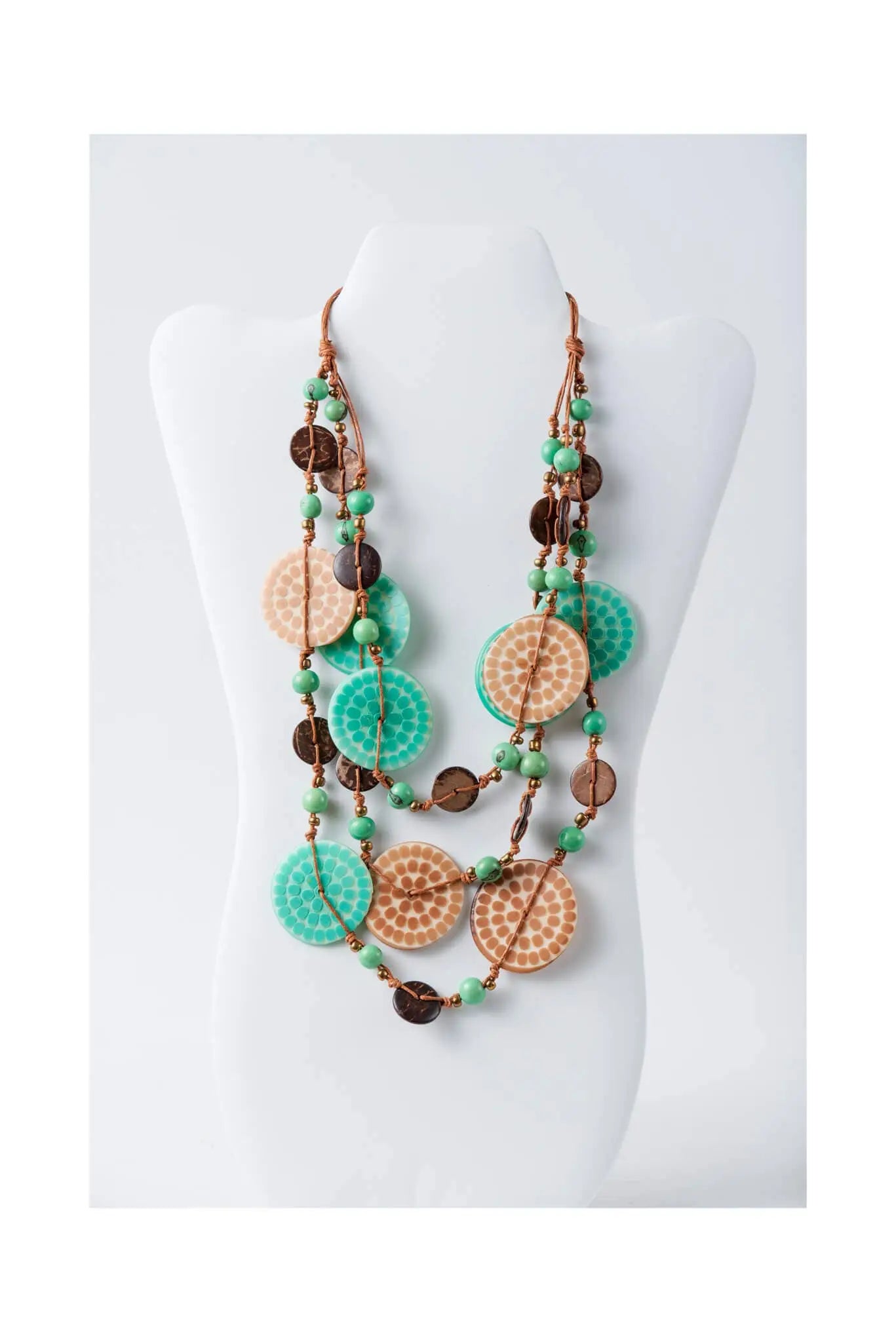 Layered necklace with engraved tagua beads in turquoise and tan featuring green jade-like spheres and dark brown accents