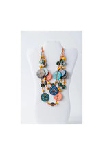 A vibrant layered necklace with teal coral and navy engraved tagua beads accented by yellow seed beads from lana eco-chic