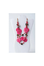 Vibrant pink layered necklace with engraved tagua beads and dark brown coconut accents on adjustable chain
