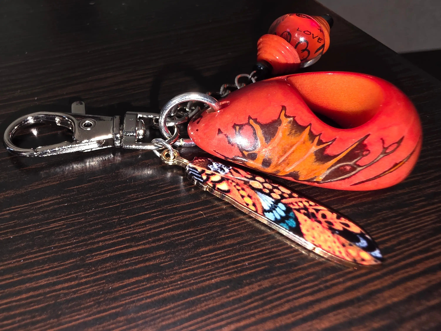 Large carved and polished rust orange tagua handmade bag charm keychain with vibrant orange and black butterfly design