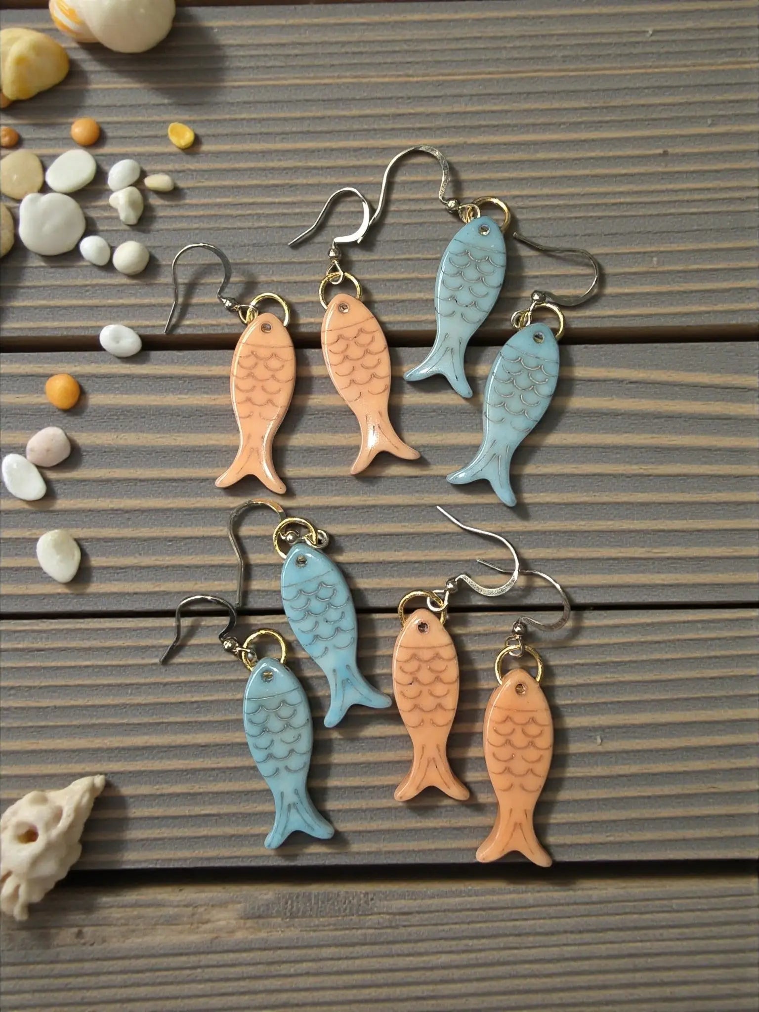 Little fishes katie earrings celeste feature glossy enamel fish shapes in soft peach and light blue with detailed scales