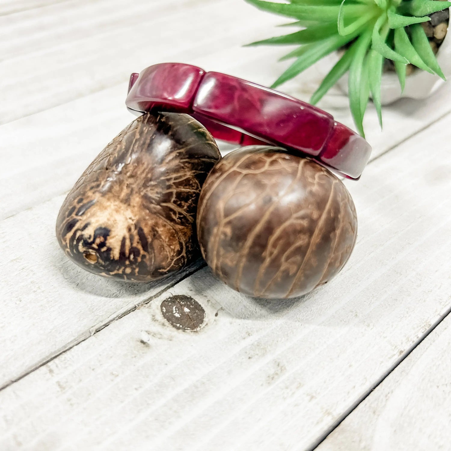 Loja bracelet eggplant is a glossy burgundy bangle with a rectangular design resting on natural coconut shell beads