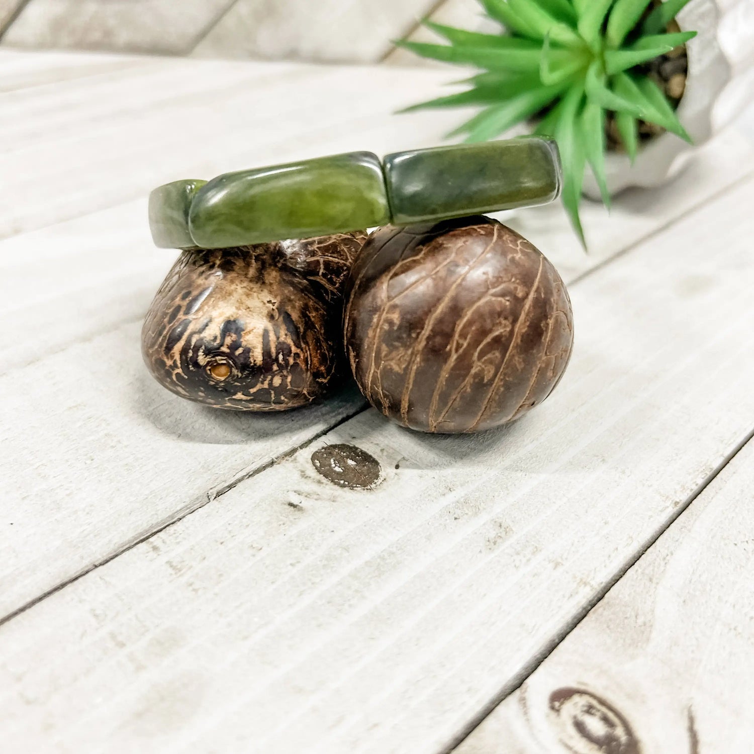 Loja bracelet forest is a smooth olive-green jade bangle with polished segmented design on coconut shells