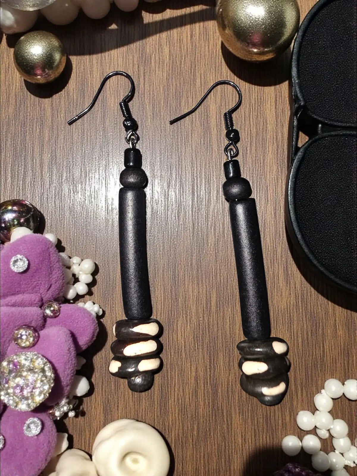 Long black tagua big bead tube earrings featuring black and cream ceramic drop with wood bead accents in handcrafted design