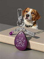 Purple teardrop-shaped tagua bag charm with white floral paw print design silver love tag and purple beads
