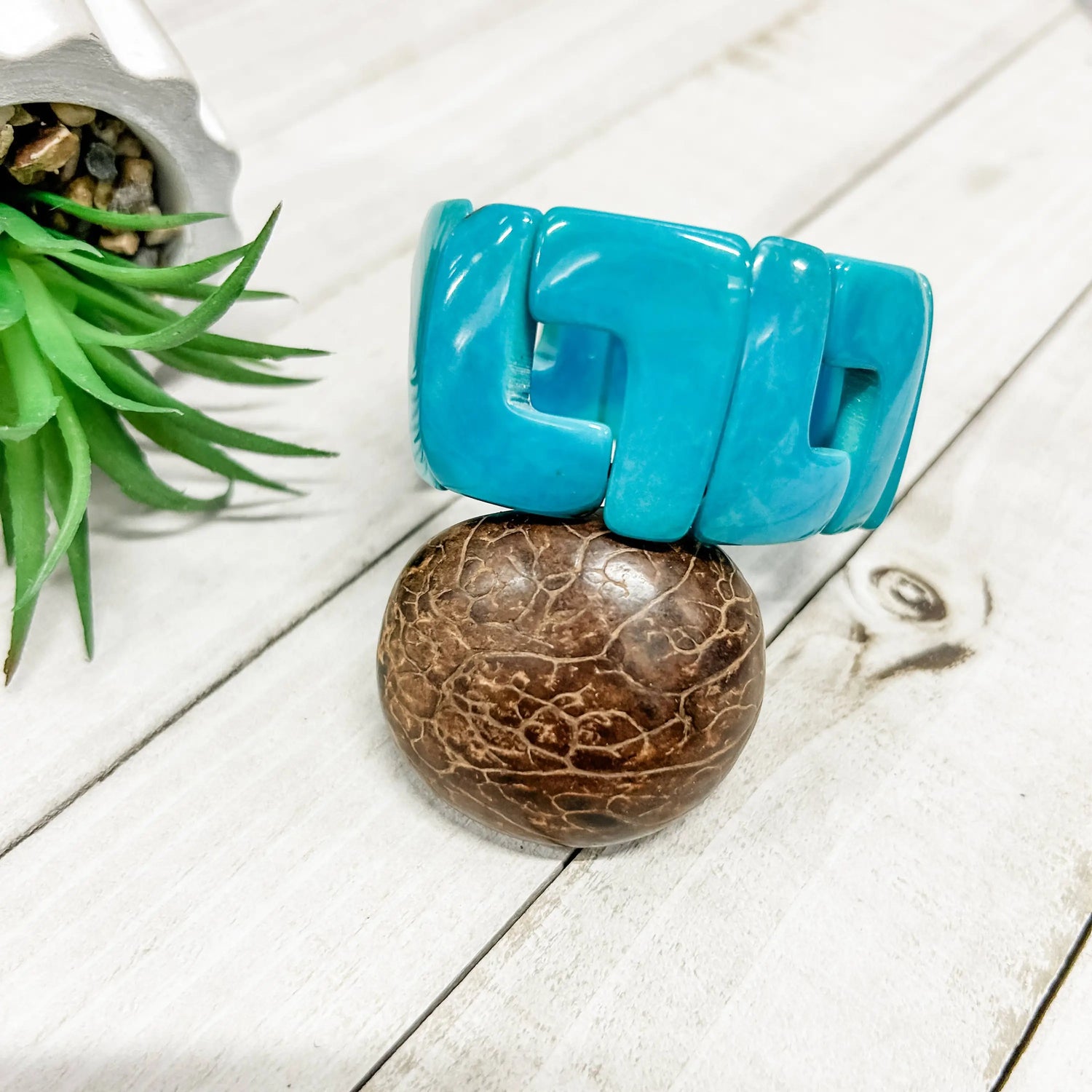 Vibrant turquoise plastic bangle with bold geometric design perfect for adding a pop of color to any outfit