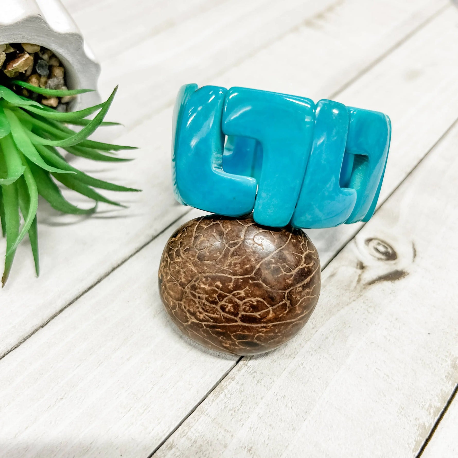 Vibrant turquoise plastic bangle with bold geometric design perfect for adding a pop of color to any outfit