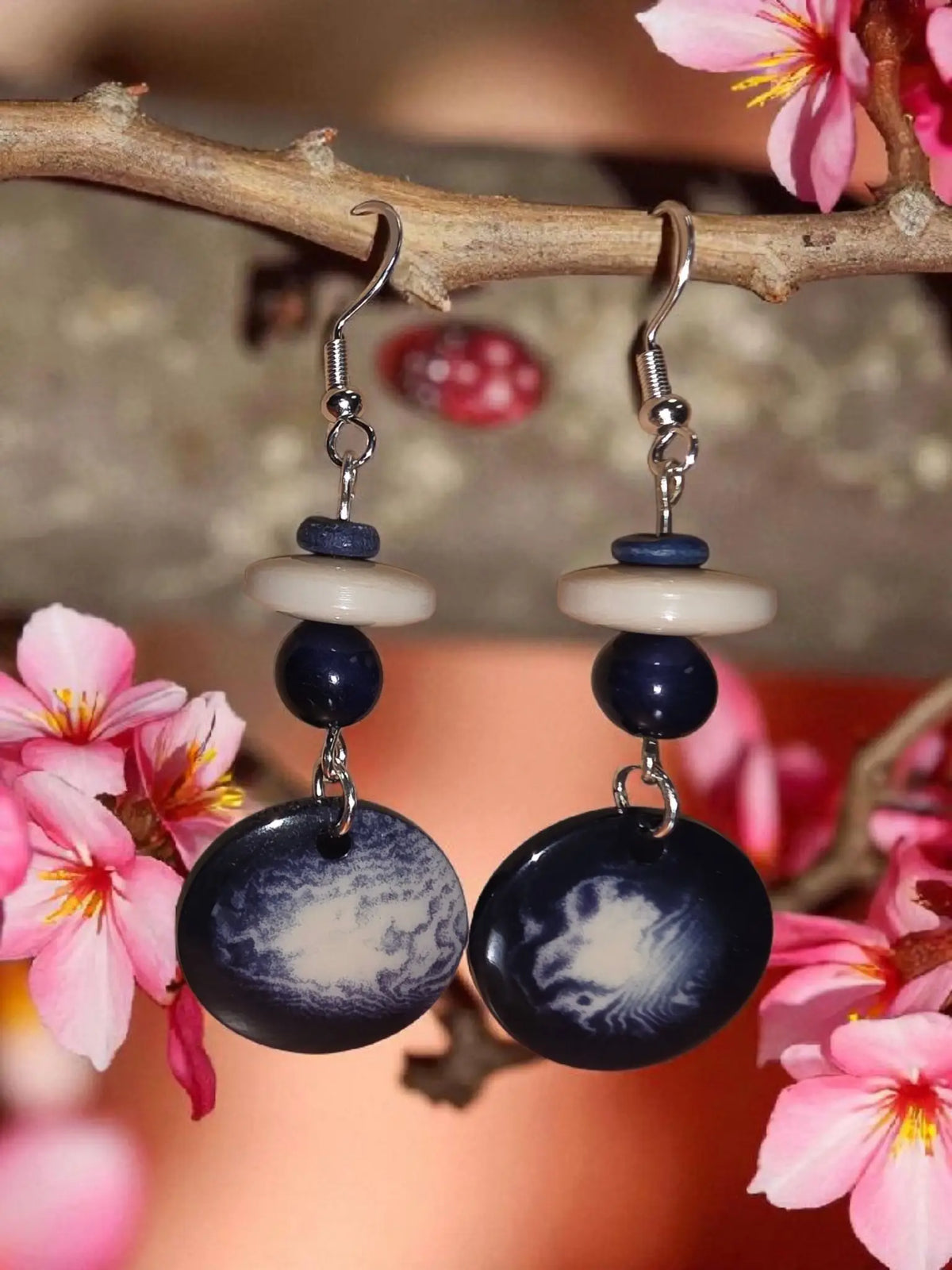 Dark blue circular vegetable ivory earrings with swirling white patterns and silver hook from misty collection usa