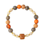 Handcrafted mika bracelet with orange and gray stones, cream tagua nut beads, and gold metallic spacers