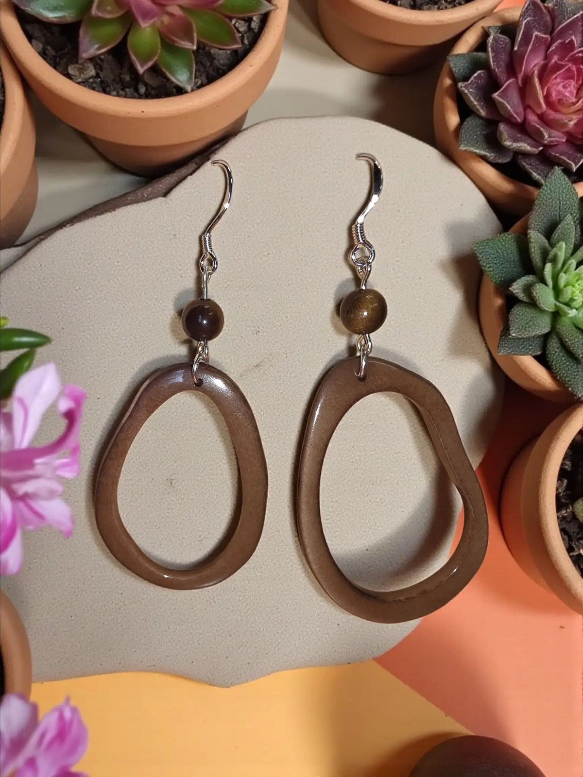 Mocha thin polished tagua hoop earrings with brown oval-shaped glossy tagua and silver hooks