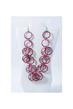 A layered necklace with chunky pink and translucent purple tagua circles hanging from gold-toned hooks