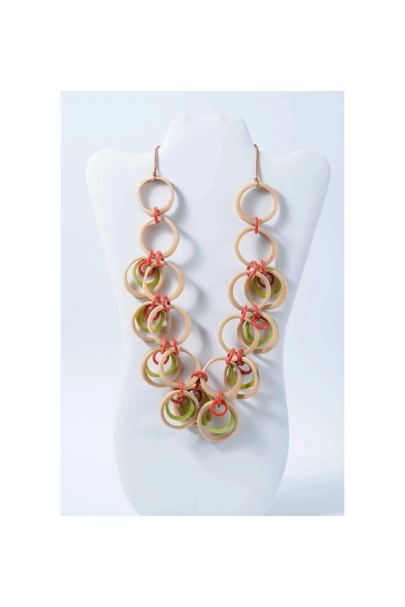 A pair of earrings with interconnected wooden tagua circles in natural tones and vibrant coral cords