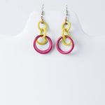 Bright yellow and fuchsia pink layered circle tagua earrings with a modern design for statement looks