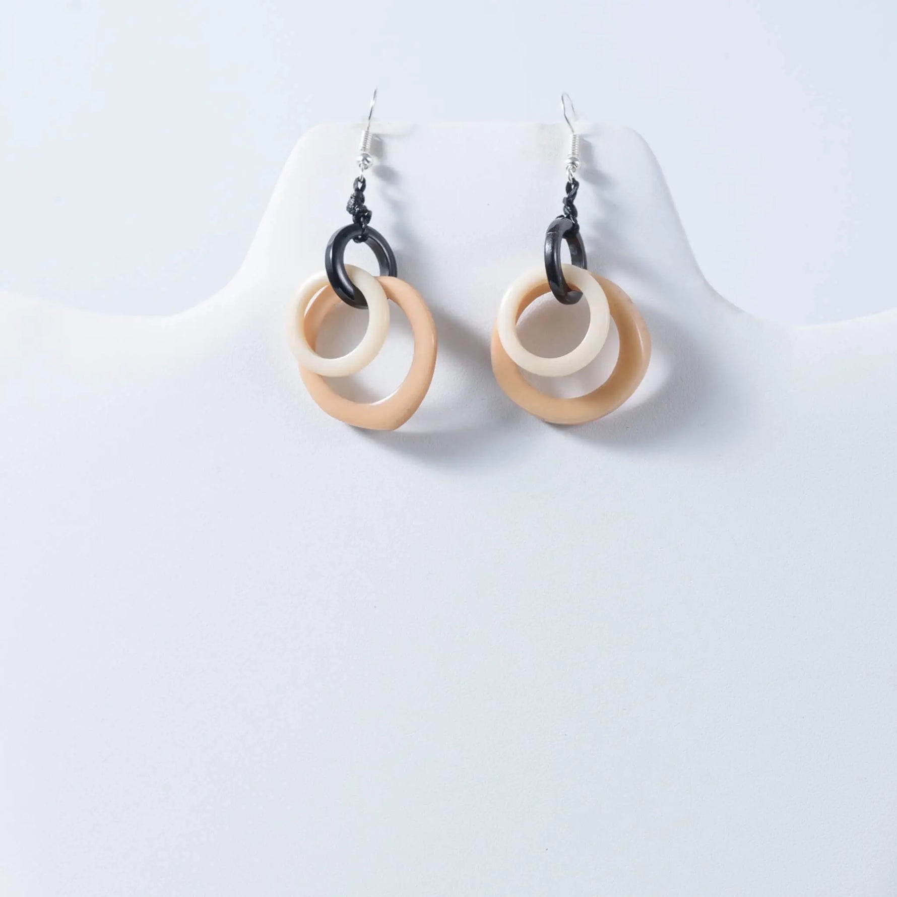 Beige and black circular hoop tagua earrings with a sleek modern design perfect for statement style
