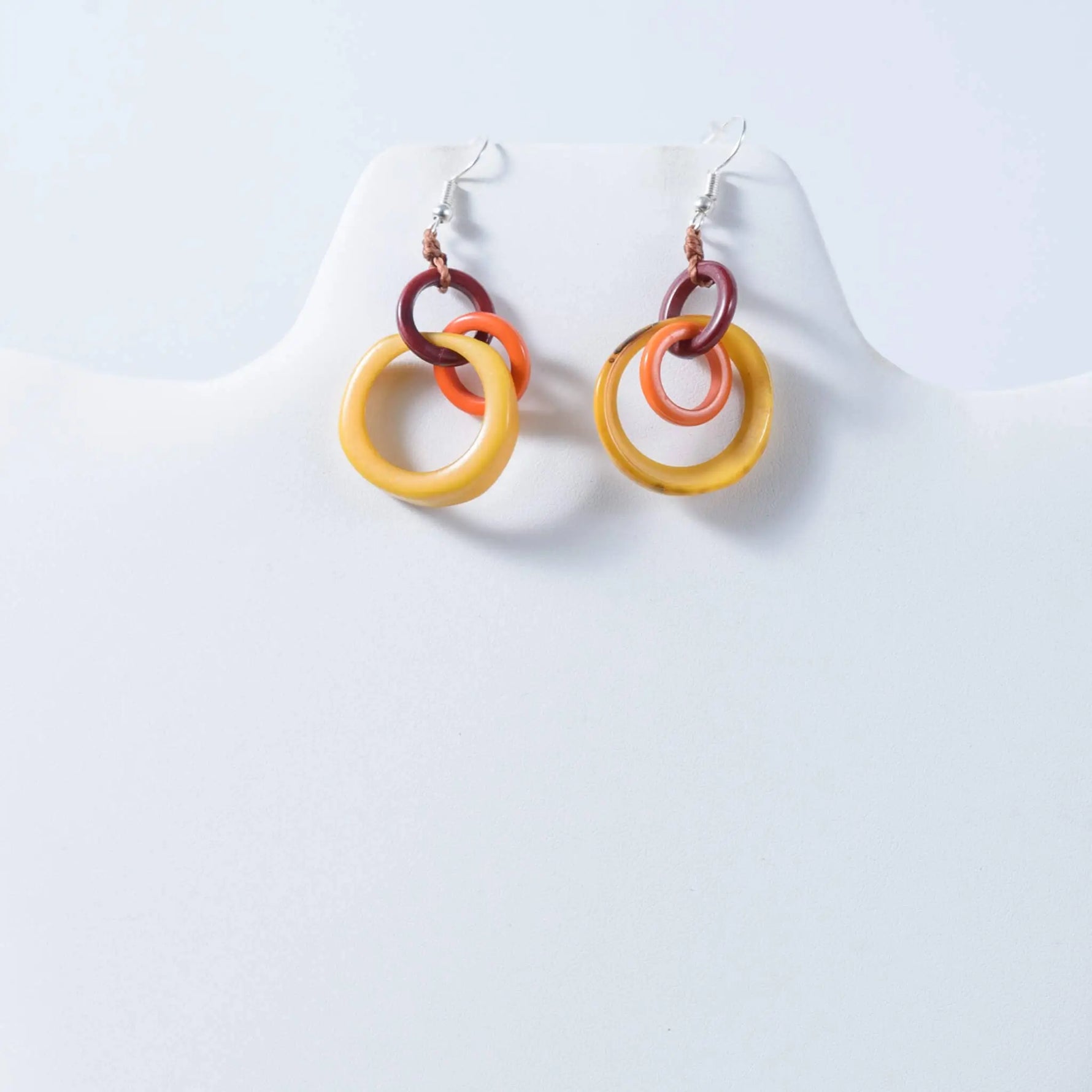 Vibrant multi-colored resin hoop tagua earrings with stacked yellow orange and maroon rings for statement style