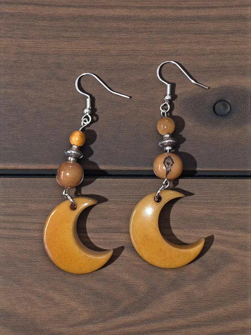 A pair of amber crescent moon carved tagua nut earrings with silver hooks and beads lightweight from the rainforest
