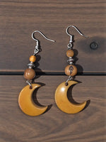 A pair of amber crescent moon carved tagua nut earrings with silver hooks and beads lightweight from the rainforest