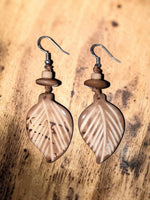 Sun & Wing Studio tan leaf-shaped earrings carved from sustainable Tagua nut with natural wood-toned accents.