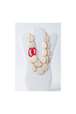 Cream-colored oval resin beads necklace with glossy finish and bold red circular links in naty dual-strand tagua necklace
