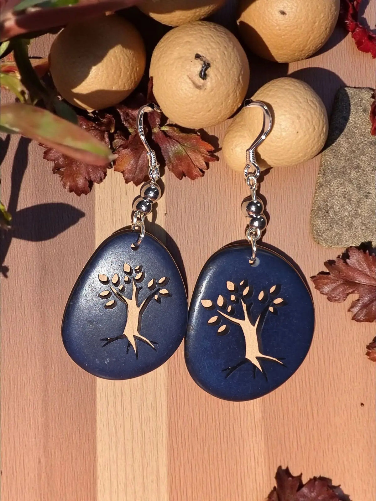 Deep blue teardrop tagua slice earrings with a silver tree laser cutout design