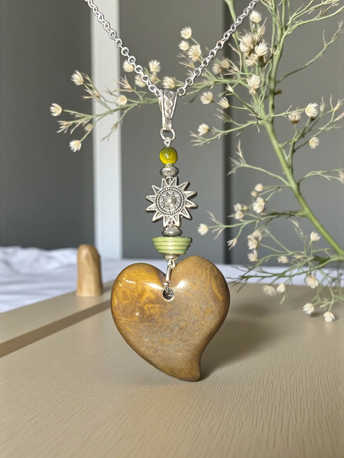 Polished olive carved heart pendant with silver sun amulet charm and green beads on delicate chain necklace